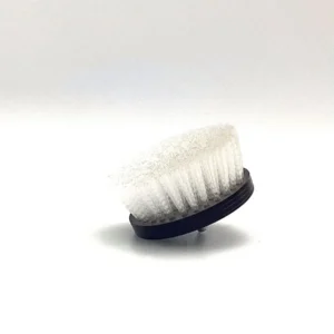 A white brush is sitting on the floor